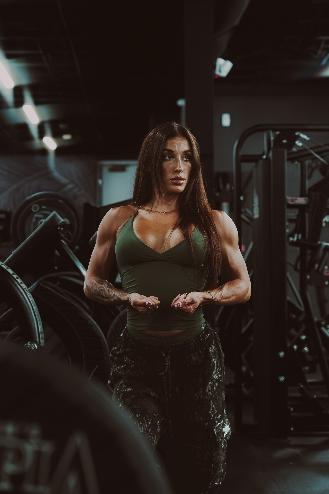 Female athlete standing among gym equipment
