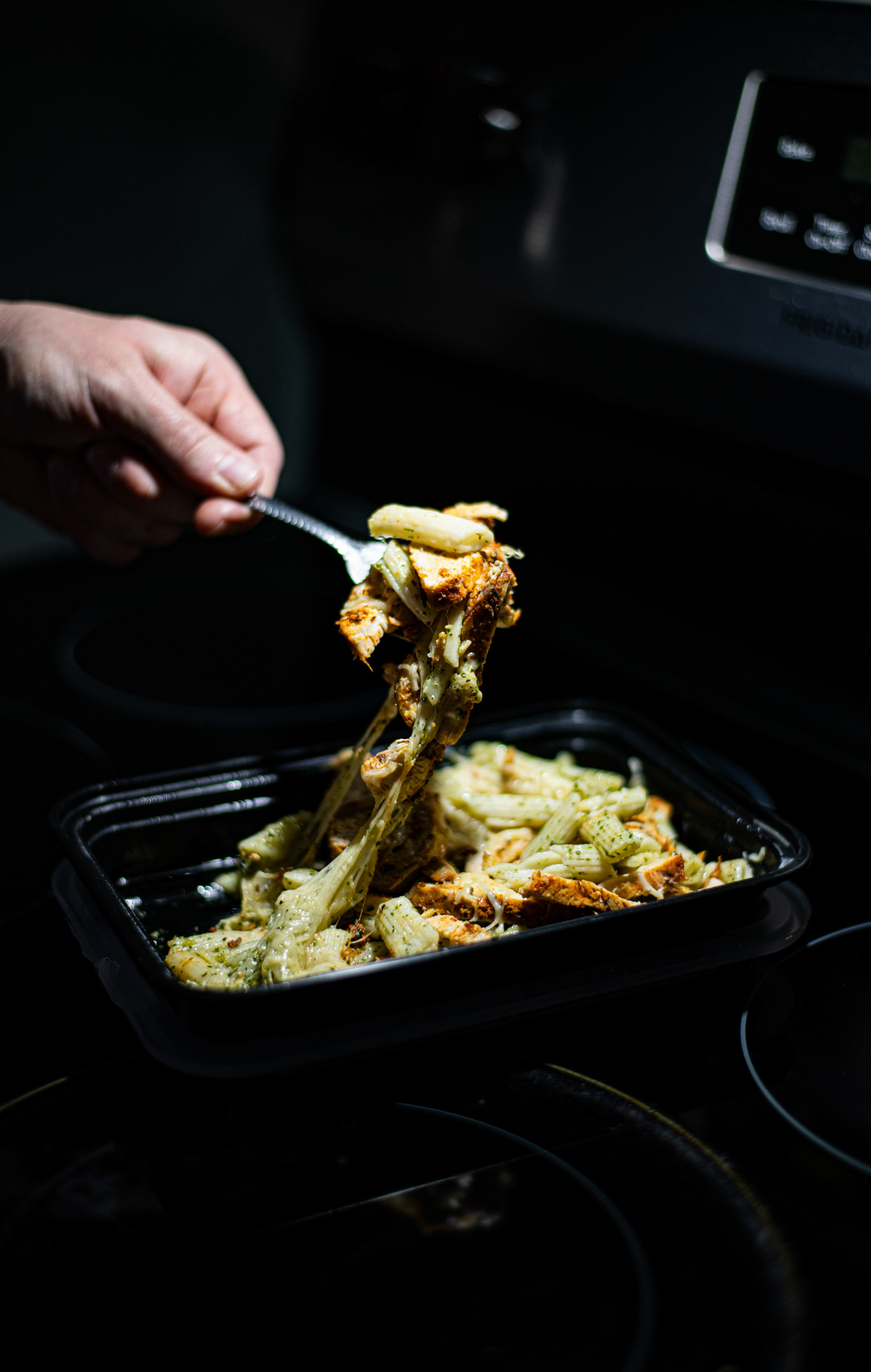 Chicken pesto pasta lifted from a meal container