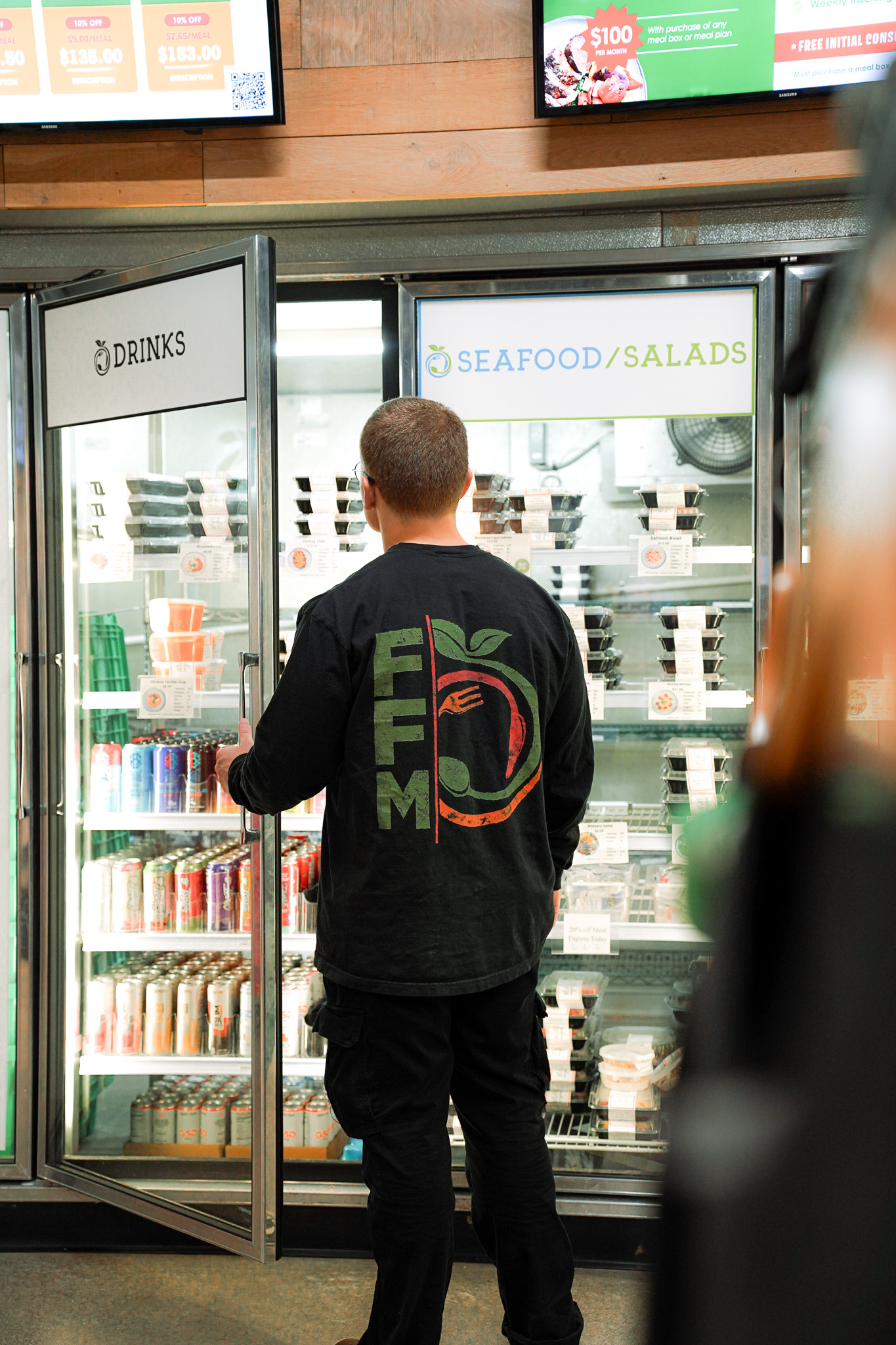Customer selecting meals from a retail cooler