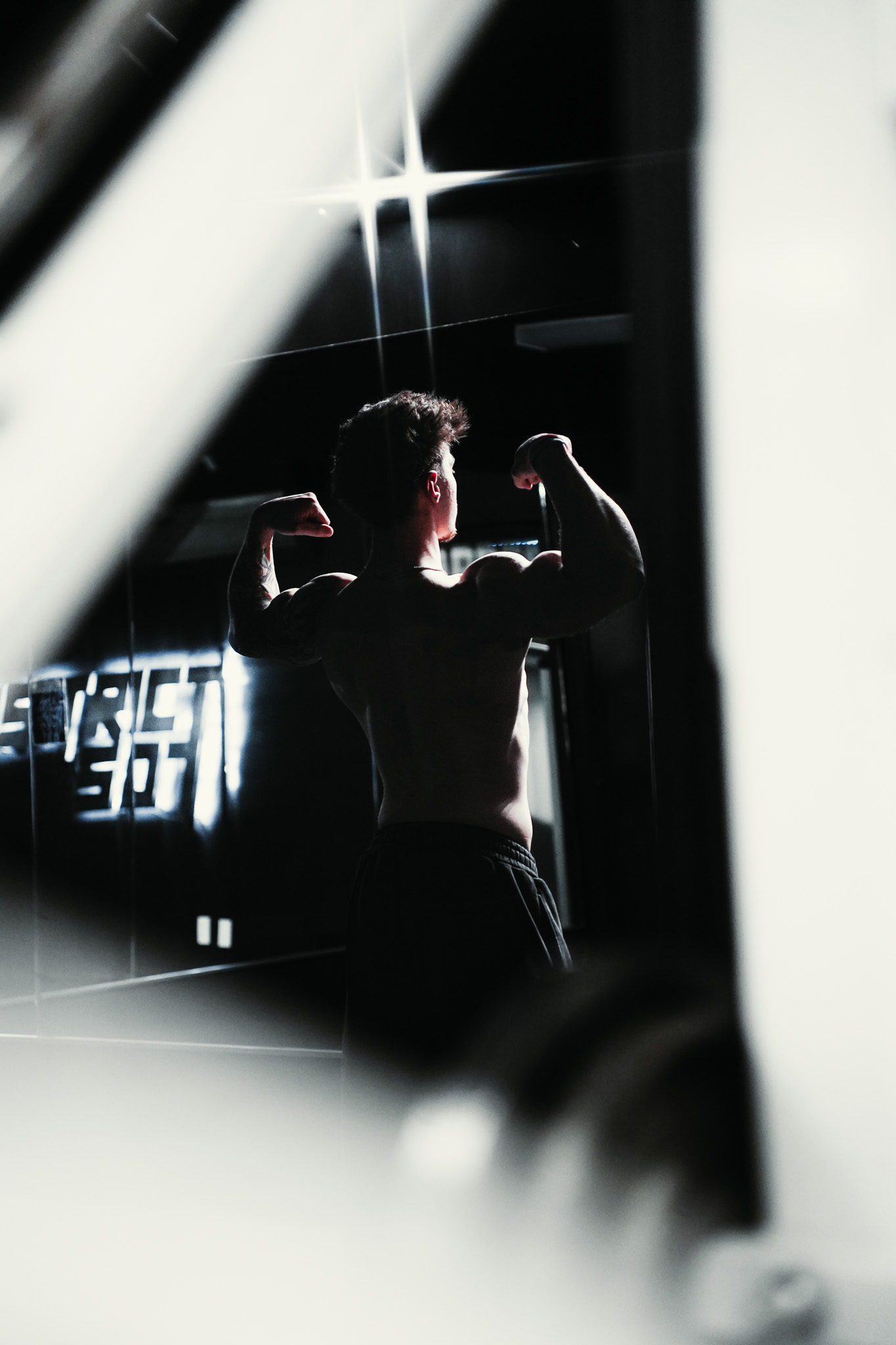 Athlete posing through a gym mirror