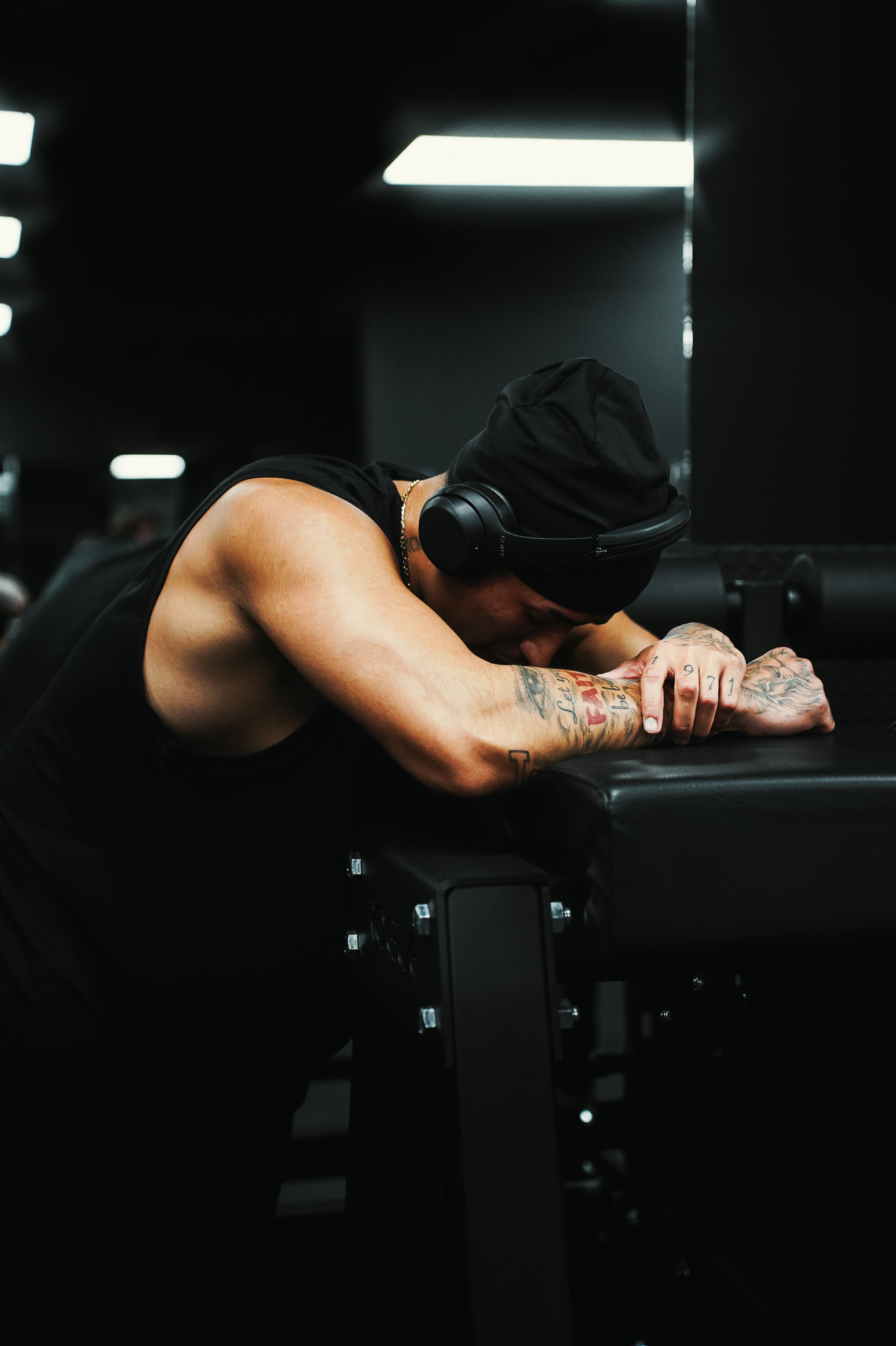 Athlete resting between sets in a dark gym