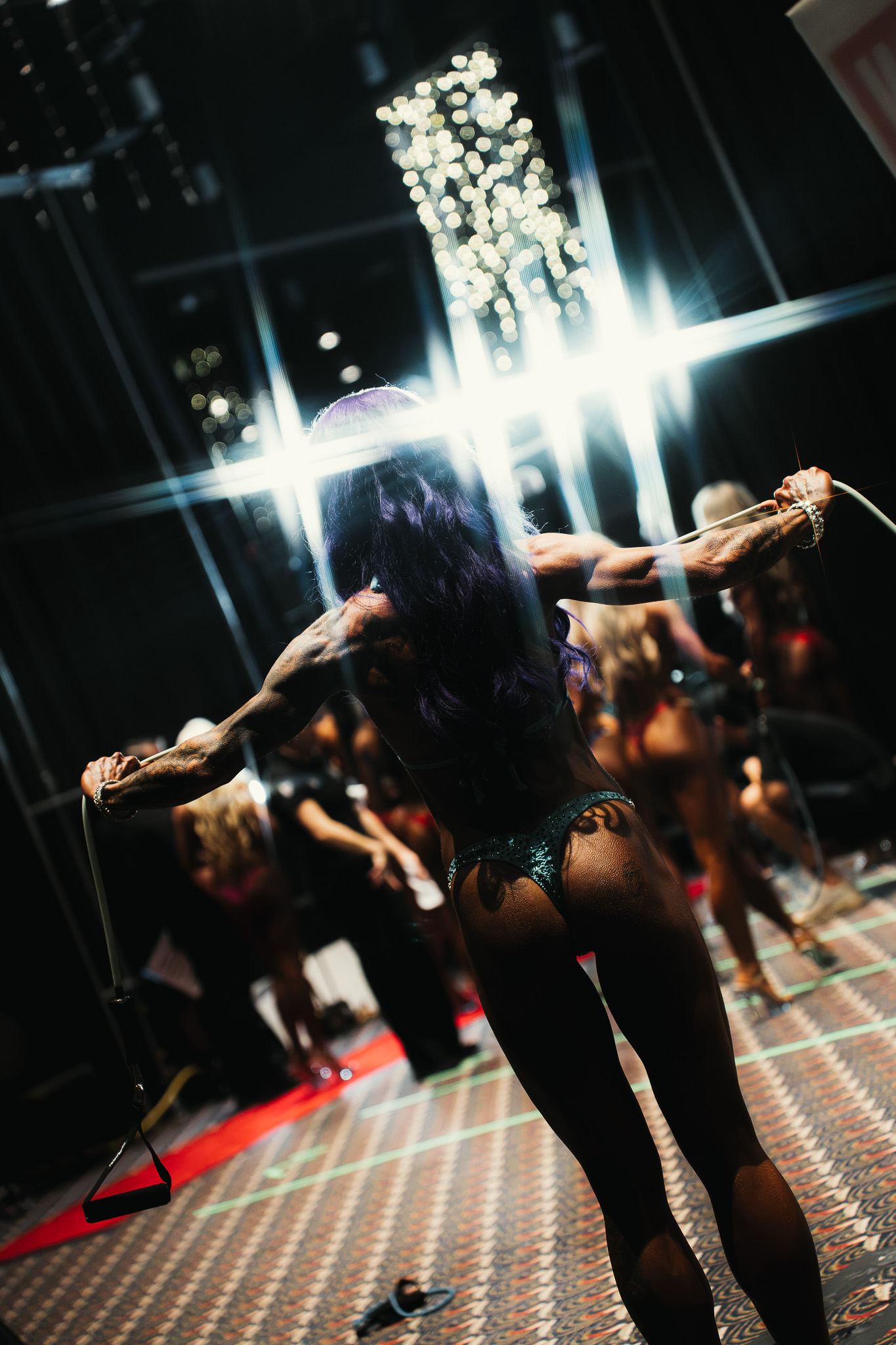 Bodybuilding athlete preparing beneath competition lights