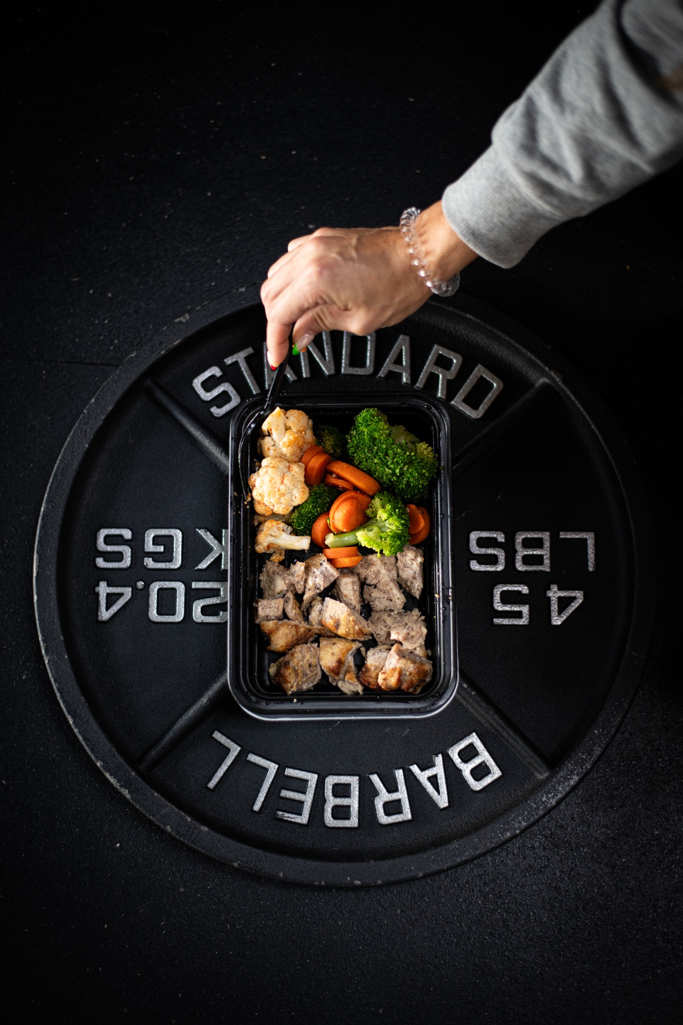 Prepared meal photographed on a barbell plate